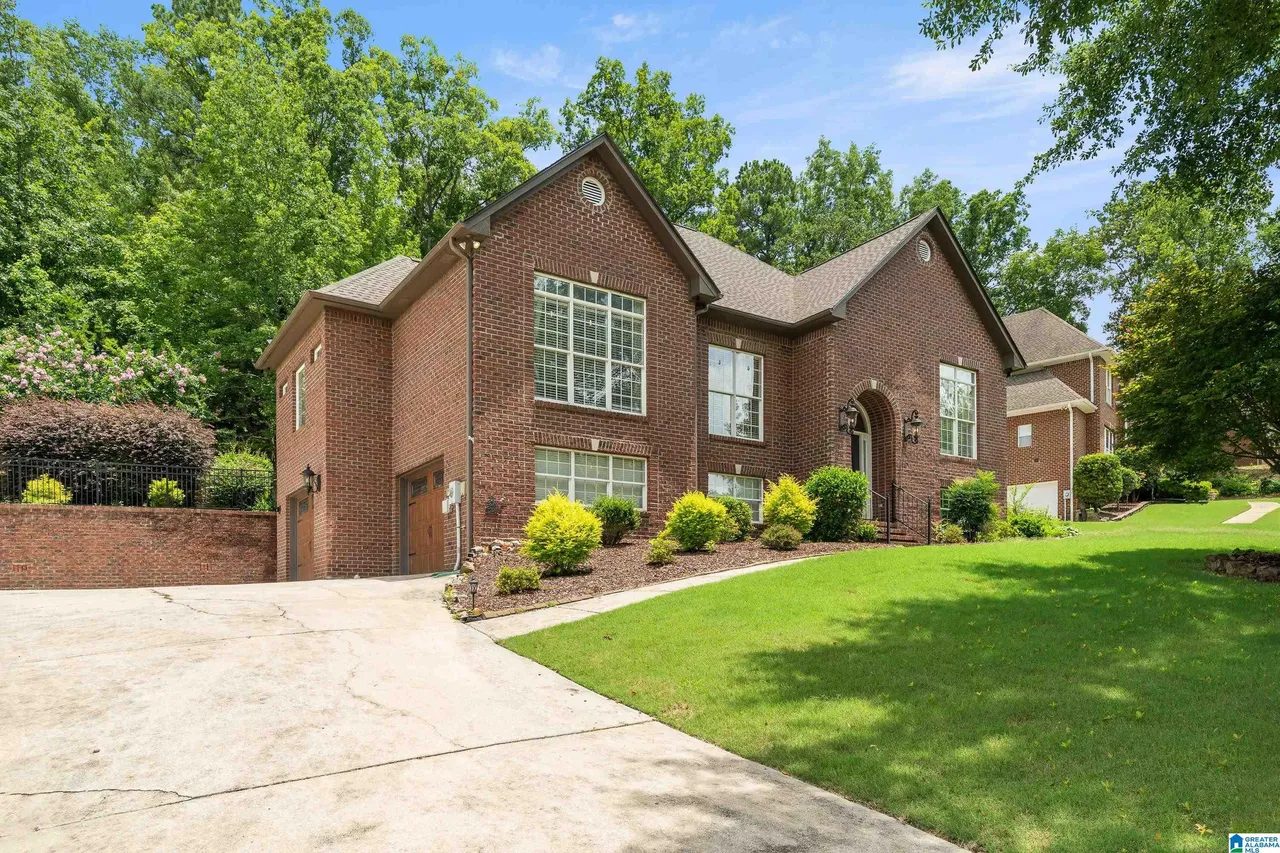 Side view of the brick home with wide driveway and lawn