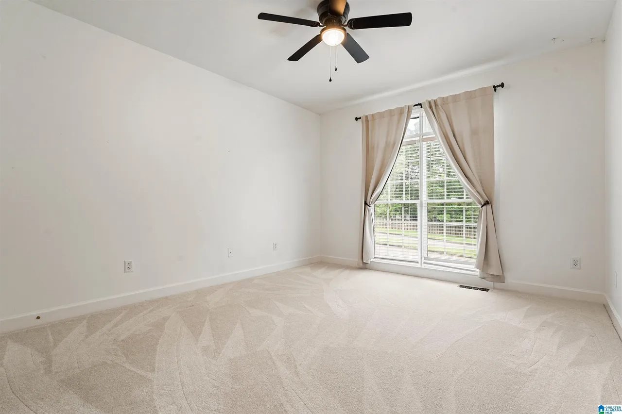 Primary bedroom with vaulted ceiling and large window